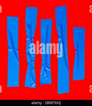 Draufsicht Set aus zerknittertem oder zerknittertem blauem Vinylklebeband oder Stoffband in Streifenform ist auf rotem Hintergrund mit Beschneidungspfad isoliert. Stockfoto