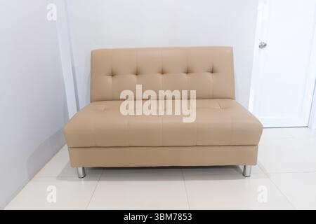 Vorderansicht des beigen oder cremefarbenen Einzelsofas im Hotel- oder Resortzimmer. Stockfoto