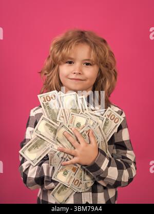 Der Junge hat viele hundert Dollar isoliert auf rosa rotem Hintergrund. Stockfoto
