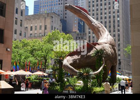 New York, USA, 24. Juni 2025. Ein fünfstöckiges Titanosaur-Modell erschien im New Yorker Rockefeller Center und zog im Rahmen einer Werbekampagne für den kommenden Film Jurassic World: Rebirth, 24. Juni 2025 Local Time eine Menge Zuschauer an. Quelle: Liao Pan/China News Service/Alamy Live News Stockfoto