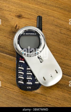Mailand, Lombardei, Italien - 30. April 2025 : Motorola V70 Vintage-Handy mit offener Klappabdeckung liegt auf einem Holztisch Stockfoto
