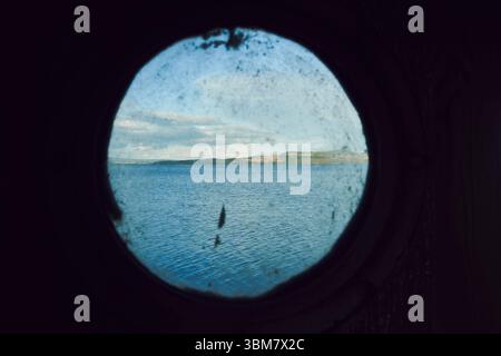 Blick auf die Insel Helgoya im See Mjosa durch das Fenster einer alten Fähre. Stockfoto