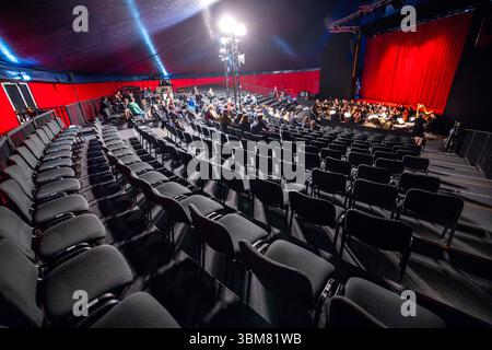 Schwerin, Deutschland. Juni 2025. Leere Stühle stehen vor einer Probe für die Operette „die fröhliche Witwe“ im neuen Theaterzelt des Mecklenburgischen Staatstheaters. Das Stück feiert seine Premiere am 27.06.2025. Aufgrund umfangreicher Bauarbeiten im historischen Bühnengebäude sind in der Spielzeit 2025/2026 sechs Inszenierungen im Theaterzelt geplant. Neben Theaterstücken, Balletten, Opern und Operetten wird das Mecklenburgische Staatsorchester auch seine Konzerte im Zelt aufführen. Quelle: Jens Büttner/dpa/Alamy Live News Stockfoto