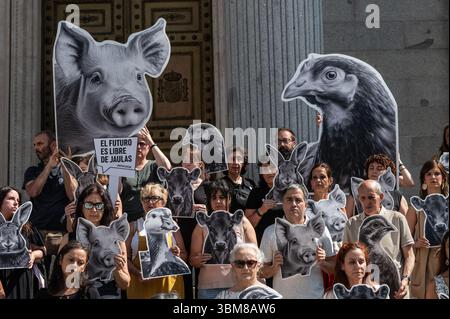 Madrid, Spanien. Juni 2025. Tierschutzaktivisten und Mitglieder der spanischen Koalition „End the Cage age“ versammelten sich mit Bildern von Nutztieren vor dem Abgeordnetenkongress, um ein gesetzliches Verbot der Verwendung von Käfigen in der Tierhaltung in der gesamten Europäischen Union zu fordern. Quelle: Marcos del Mazo/Alamy Live News Stockfoto