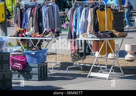 Flohmarkt mit gebrauchten Kleidungsstücken, Taschen und Schuhen zum Verkauf an einem sonnigen Tag, ausgewählter Fokus, enge Schärfentiefe Stockfoto