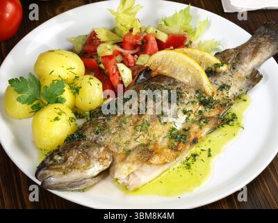 Gegrillte Forelle mit Kartoffeln und Salat Stockfoto