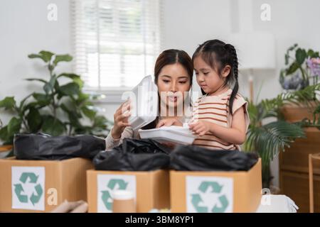 Umweltbewusstsein und Lernmomente. Mutter und Tochter arbeiten an Recycling und entdecken dabei die Bedeutung einer verantwortungsvollen Entsorgung. Stockfoto