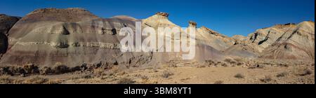Dieses malerische Panorama zeigt die bunten Formationen der Bentonite Hills unter einem klaren blauen Himmel in der Nähe des Capitol Reef National Park, Utah. Stockfoto