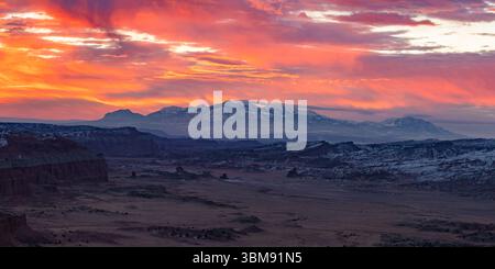 Ein dramatischer, farbenfroher Himmel unterstreicht dieses Winterpanorama auf dem Capitol Reef National Park und den schneebedeckten Henry Mountains in Utah. Stockfoto
