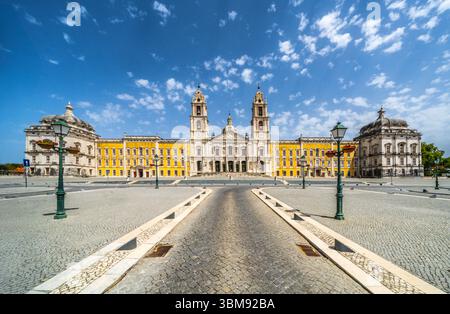 Nationalpalast Mafra, Portugal. Großer barocker und neoklassizistischer königlicher Komplex mit Basilika und Twin-Türmen unter blauem Himmel. UNESCO-Weltkulturerbe. Stockfoto