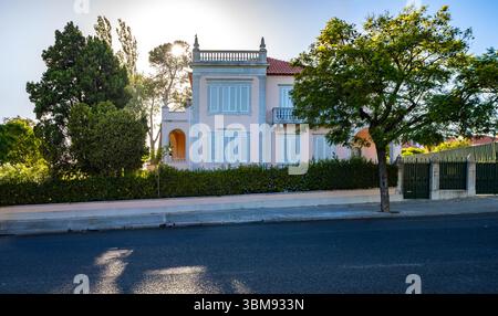 Elegante portugiesische Villa mit neoklassizistischer Fassade an der Avenida da Torre de Belém, Lissabon, mit traditionellen blauen Fensterläden und verzierten Details Stockfoto