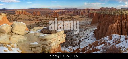 Dieses Winterpanorama zeigt einen einzigen schwarzen Vulkanfelsen auf einem Abgrund mit Blick auf das Cathedral Valley im Capitol Reef National Park, Utah. Stockfoto
