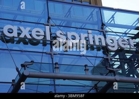 Das Axel Springer Logo am Eingang des alten Hauptquartiers des deutschen Medienunternehmens, goldener Wolkenkratzer, in der Berliner Innenstadt Stockfoto