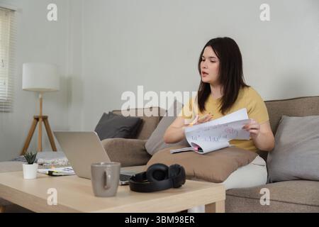 Remote-Arbeit und virtuelle Meetings. Eine fokussierte Frau, die an einem Videoanruf mit Arbeitsdokumenten teilnahm. Stockfoto
