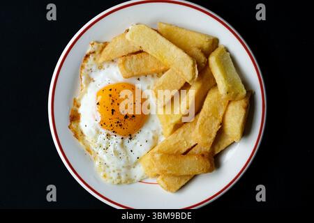 London UK Juni 25 2025, Fried Egg Sunny Side Up mit Thick Cut Chuncky Chips Stockfoto