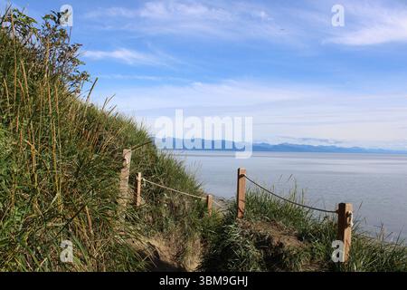 Foto von einem Küstenwanderweg mit Bergblick. Aufgenommen in Anchorage, Alaska während des 24-Stunden-Tageslichtphänomens im August 2022 Stockfoto