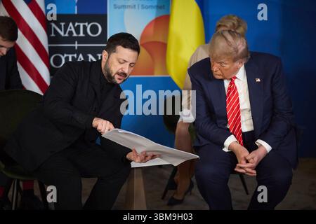 Den Haag, Niederlande. Juni 2025. US-Präsident Donald Trump, rechts, sieht zu, wie der ukrainische Präsident Wolodymyr Zelenskyj, links, ihm Dokumente während seines bilateralen Treffens am Rande des NATO-Gipfels 2025 am 25. Juni 2025 in den Haag, Niederlande, zeigt. Kredit: Ukrainischer Ratsvorsitz/Pressestelle Des Ukrainischen Präsidenten/Alamy Live News Stockfoto