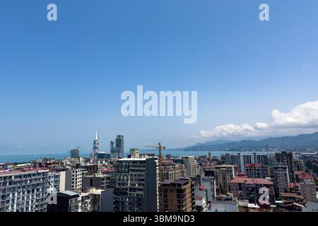 Panoramablick auf die Skyline von Batumi mit moderner Architektur, die Schwarzmeerküste und die Berge, die das städtische Wachstum und den Tourismus in Georgien veranschaulichen. Stockfoto