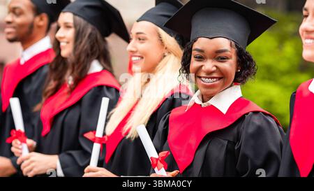 Glückliche schwarze Dame lächelt während der Abschlussfeier an der Kamera Stockfoto