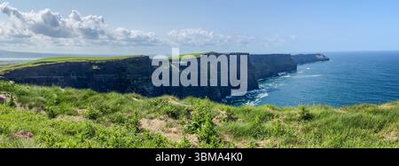 Cliffs of Moher. Irlands dramatische Küstenklippen treffen unter sonnigem Himmel auf den riesigen Atlantik. Ein beliebtes Naturdenkmal für Tourismus und trave Stockfoto
