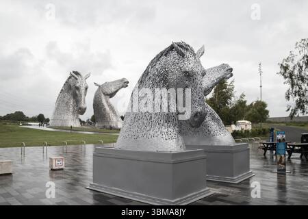 Mini Kelpies vor dem Visitor Centre im Helix Park, große Kelpies im Hintergrund Stockfoto