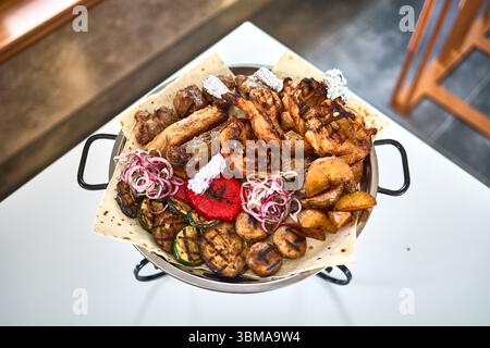 Gemischtes Grillfleisch mit Kartoffeln und Gemüse Stockfoto