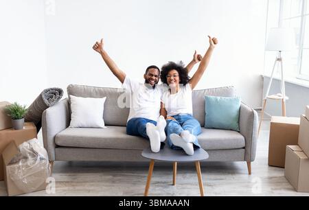 Schwarze Ehepartner Feiern Umzug Tag In New House, Gestikuling Thumbs-Up Stockfoto