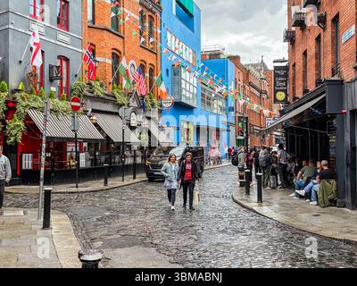Temple Bar ist eine geschäftige Straßenszene im Kulturviertel von Dublin mit Pubs, Kopfsteinpflaster und Spaziergängen. Stockfoto