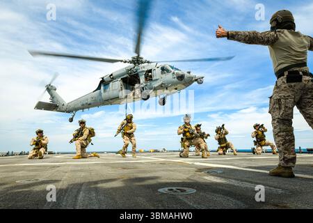 Mitglieder der 22. Marine Expeditionary Unit und der Küstenwache Marine Security Response Team East führen an Bord der USA eine Ausbildung zum Einsetzen von Hubschraubern durch Stockfoto