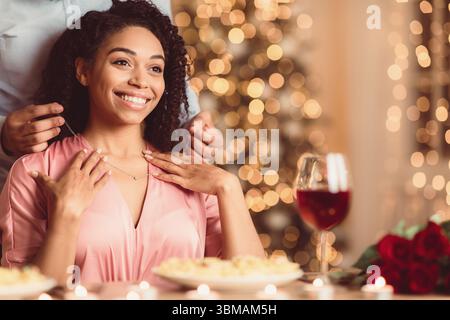 Junger schwarzer Mann mit Halskette an seiner Frau Stockfoto