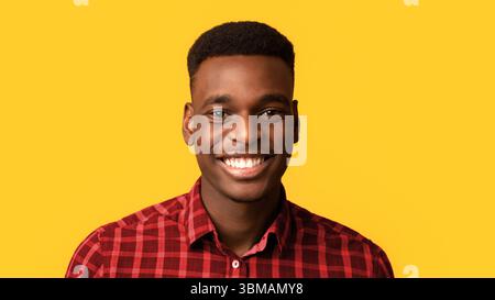 Nahaufnahme Porträt von positiven jungen afroamerikanischen Kerl aufrichtig lächelnd Bei der Kamera Stockfoto