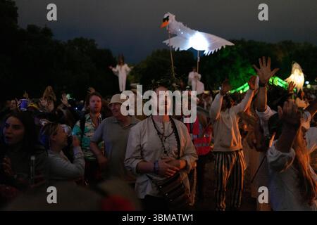 Green Fields Start in Glastonbury die Glastonbury Festivals Green Fields Area eröffnet heute Abend mit einer Zeremonie, die von der gemeinsamen Flamme der Hoffnung geleitet wird, die 15 heilige Flammen aus der ganzen Welt vereint. Ein Chor von über tausend Stimmen singt ein Friedensmantra in Kings Meadow, gefolgt von einem spektakulären Feuerwerk. Die Veranstaltung schafft ein starkes Gefühl von Einheit und Zweck und markiert den offiziellen Beginn des Festivals in diesem ruhigen, spirituellen Herzen der Website London England Vereinigtes Königreich Copyright: xx Stockfoto