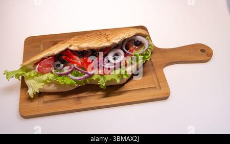 Ein Döner Döner ist ein beliebtes Essen zum Mitnehmen, das aus dünnen Scheiben besteht, die aus einem zylindrischen Block gehackten und gewürzten Fleisches (Rindfleisch, Lamm oder Huhn) geschnitten werden. Stockfoto
