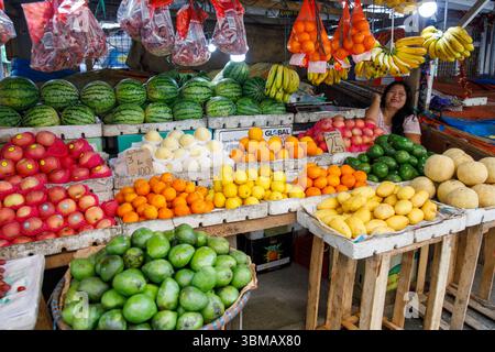 13. Mai 2025: Calapan City, Philippinen, Verkäuferin am Obststand, die Mangos Orangen Melonen Bananen und Wassermelonen auf dem öffentlichen Markt verkauft Stockfoto