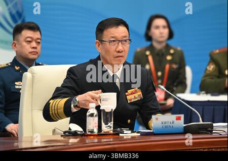 Qingdao, China. Juni 2025. Chinas Verteidigungsminister Dong Jun trinkt während des Treffens der Verteidigungsminister der Shanghai Cooperation Organization (SCO) aus einem Becher. Die SCO besteht aus zehn staaten, darunter China, Russland, Iran, Pakistan und Kasachstan. Sie wurde ursprünglich 2001 zur Bekämpfung des Terrorismus gegründet und verfolgt nun auch Ziele wie Sicherheit und wirtschaftliche Zusammenarbeit. Quelle: Johannes Neudecker/dpa/Alamy Live News Stockfoto