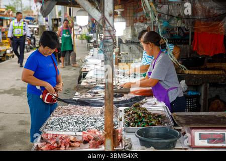 13. Mai 2025: Frauen verkaufen frischen Fisch und Meeresfrüchte auf dem Outdoor Wet Market in Calapan City, Philippinen Stockfoto