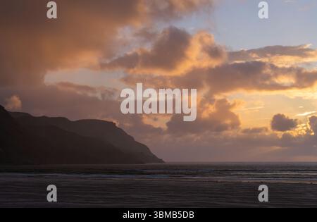 Sonnenuntergang Wolkenlandschaft über dem Atlantik vom Maghera Beach aus, welliger Sand bei Ebbe und eine Silhouette von Landzunge in der Nähe von Ardara, County Donegal, Irland. Stockfoto