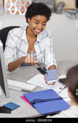 Das junge Reisebüro gibt Kundenunterlagen aus Stockfoto