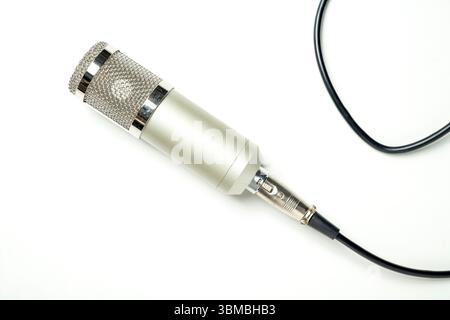 Studio-Mikrofon für Podcasting oder Streaming mit angeschlossenem Kabel auf weißem Hintergrund. Draufsicht Stockfoto