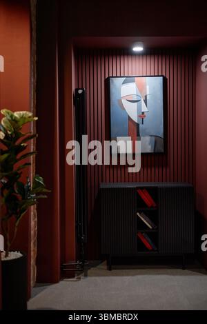 Abstraktes Gemälde mit geometrischem menschlichem Gesicht, das an der Wand im modernen Innenraum hängt Stockfoto