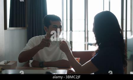 Liebevolles Paar schlürft Kaffee und teilt intime Gespräche im minimalistischen urbanen Wohnraum Stockfoto
