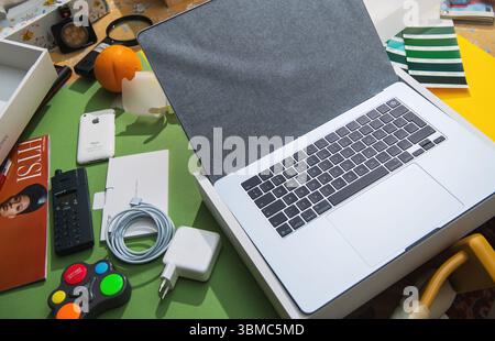 Paris, Frankreich – 13. März 2025: Das neue MacBook Air M4 wird mit Zubehör und Retro-Technik auf einem farbenfrohen Schreibtisch ausgepackt. Stockfoto