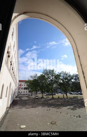 ChatGPT sagte: MÜNCHEN, DEUTSCHLAND - 24. JUNI 2025: Geschwungener Architekturrahmen, der einen Blick auf den Innenhof der LMU und historische Gebäude in eröffnet Stockfoto