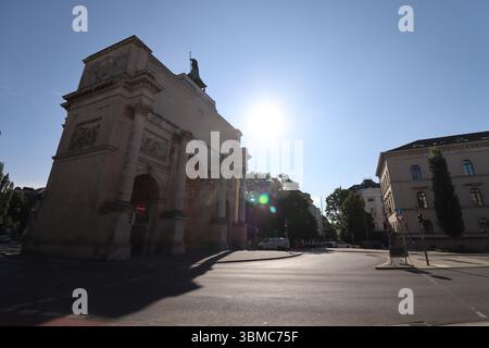 MÜNCHEN - 24. JUNI 2025: Sonnendurchfluteter Blick auf den Siegestor-Triumphbogen und die umliegenden Gebäude in der Ludwigstraße am Morgen Stockfoto