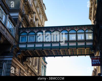 Vereinigtes Königreich, London, 23. Juni 2025. Historische überdachte Fußgängerbrücke am Leadenhall Market in der City of London mit detaillierter viktorianischer Architektur Stockfoto