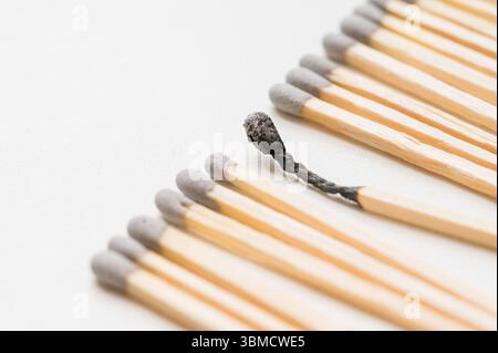 Gruppe von Streichhölzern und ein verbranntes Match, verbranntes abstraktes Konzept Stockfoto