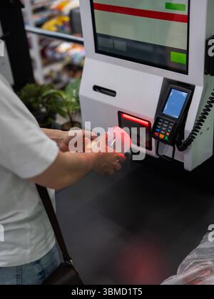 Eine Frau scannt Artikel an einer Selbstkasse. Stockfoto