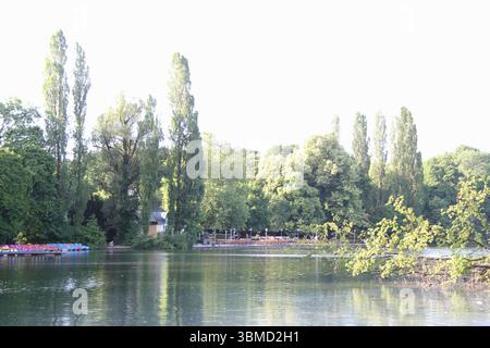 MÜNCHEN, DEUTSCHLAND - 24. JUNI 2025: Blick auf Bäume und Bootsverleih am Kleinhesseloher See im Englischen Garten in München Stockfoto