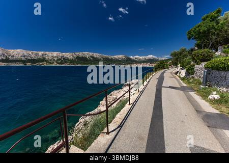 Ein Weg für Radfahrer und Wanderer entlang der Küste in Baska auf der Insel KRK, ein Blick auf den Strand in Baska Stockfoto