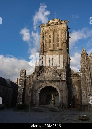 Der nach Westen ausgerichtete Turm der Kirche Saint-Ronan aus dem 15. Jahrhundert fängt das späte Sonnenlicht in Locronan ein touristisches Dorf in Finistère, Bretagne. Stockfoto